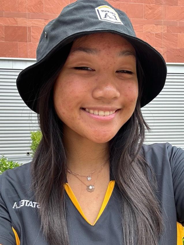 Student in bucket cap smiling.