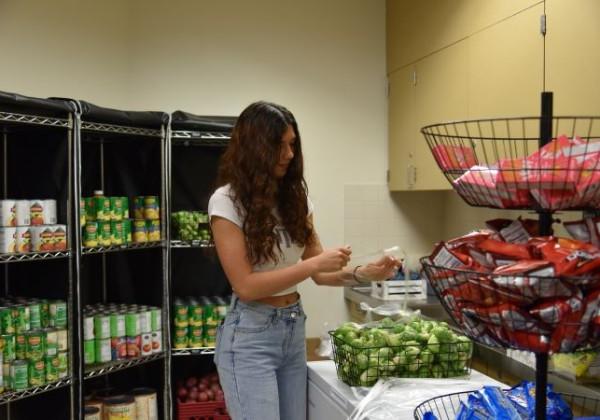 female student at the food pantry, looking at produce