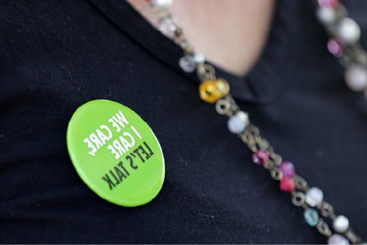 Close-up of a button that says "I care, we care, let's talk."